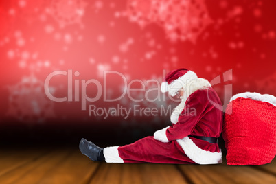 Composite image of santa sits leaned on his bag