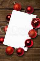 Composite image of red christmas baubles surrounding white page
