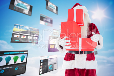 Composite image of santa covers his face with presents