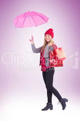 Festive blonde holding umbrella and bags