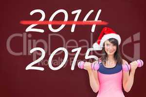 Composite image of woman in santa hat holding hand weight