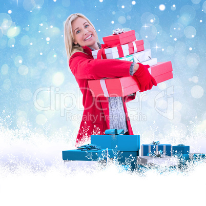 Composite image of festive blonde holding many gifts