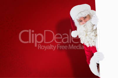 Composite image of happy santa claus holding poster