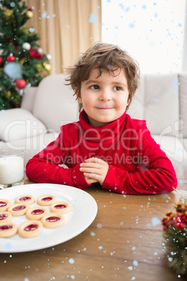 Composite image of festive little boy having milk and cookies Composite image of festive little boy having milk and cookies