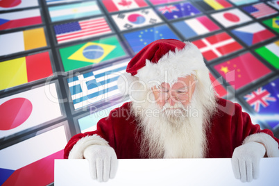 Composite image of santa holds a sign and looks down