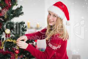 Composite image of woman decorating a christmas tree while looki