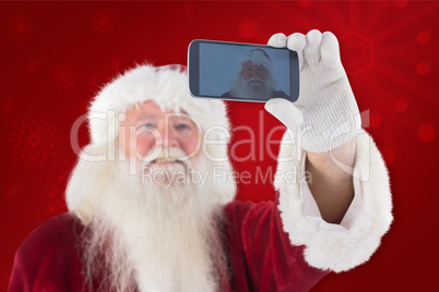 Composite image of santa taking a selfie on phone
