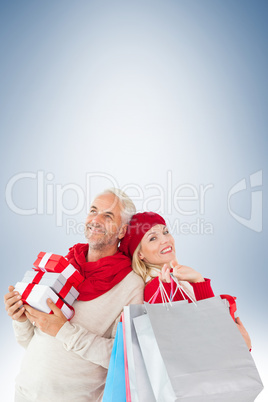 Composite image of happy festive couple with gifts and bags