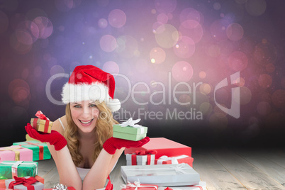 Composite image of woman in santa hat laying on the floor while