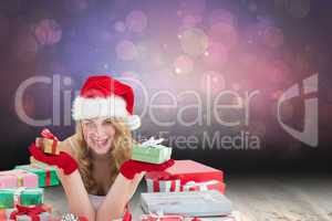 Composite image of woman in santa hat laying on the floor while