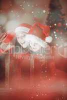 Composite image of festive mother and daughter opening a christm