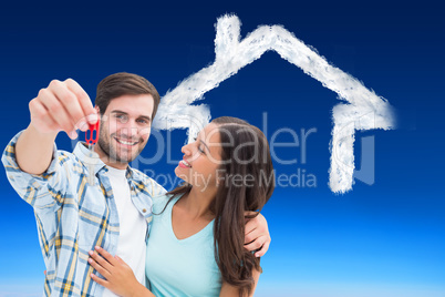 Composite image of happy young couple showing new house key