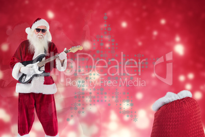 Composite image of santa claus plays guitar with sunglasses