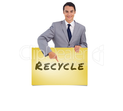 Composite image of goodlooking man holding and pointing at a big