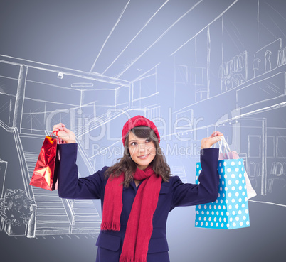 Composite image of pretty brunette holding up shopping bags