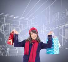 Composite image of pretty brunette holding up shopping bags