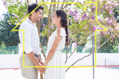 Composite image of attractive couple standing in garden holding