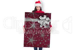 Composite image of happy brunette in santa hat showing gift card