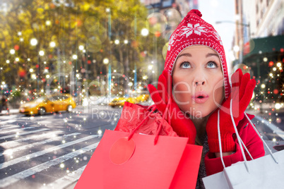 Composite image of blonde in winter clothes holding shopping bag