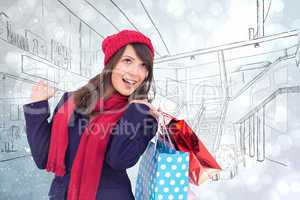 Composite image of happy brunette in winter clothes holding shop