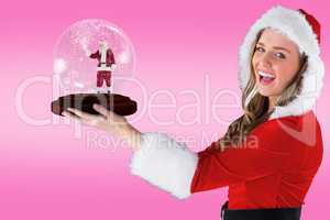 Composite image of sexy santa girl holding snow globe