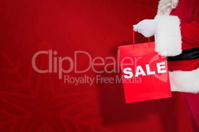 Composite image of santa claus holding sale bag