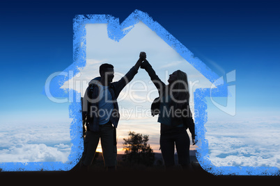 Composite image of silhouette couple holding up hands at dusk