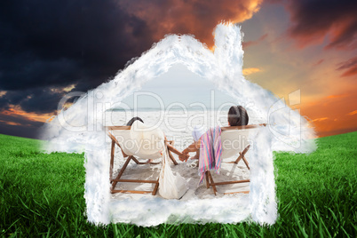 Composite image of couple looking ocean on their deck chairs