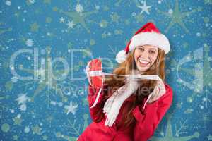 Composite image of festive redhead opening a gift