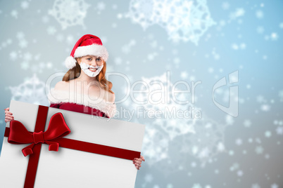 Composite image of festive redhead in foam beard holding poster