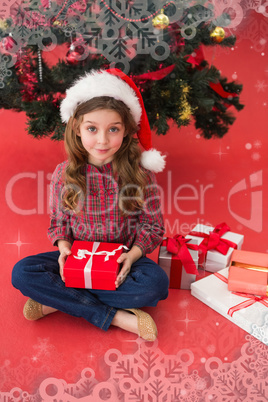 Composite image of festive little girl holding gift