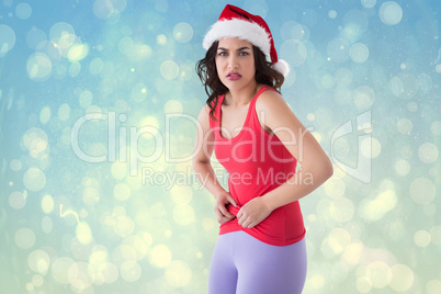 Composite image of festive fit brunette pinching her stomach