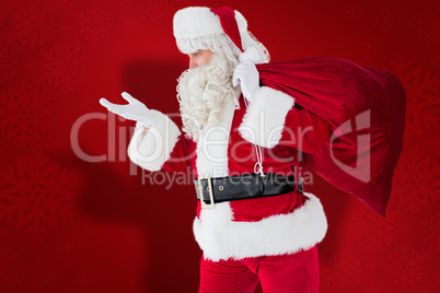 Composite image of santa with hand out and holding sack