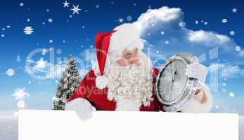 Composite image of santa holding a clock and sign