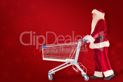 Composite image of santa pushes a shopping cart