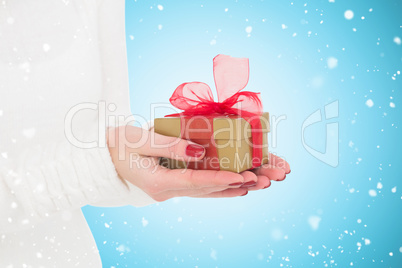 Composite image of pretty woman holding gild gift