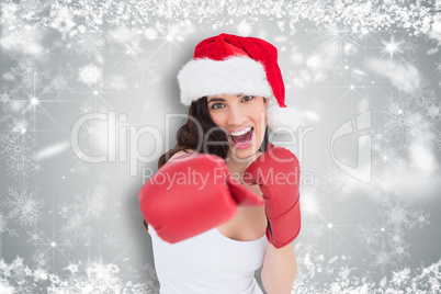 Composite image of festive brunette in boxing gloves punching