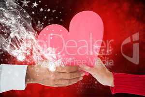 Composite image of couple holding heart