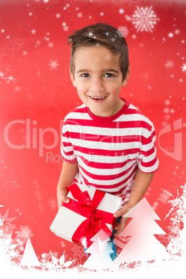 Composite image of festive little boy holding a gift