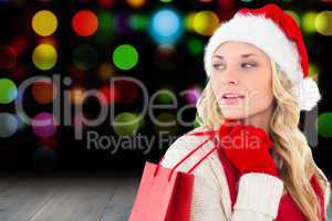 Composite image of happy festive blonde with shopping bag