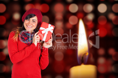 Composite image of brunette in red hat holding a gift