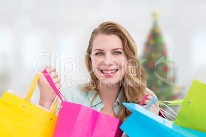 Composite image of pretty woman smiling at the camera with shopp