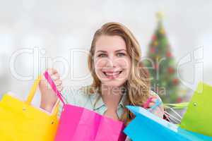 Composite image of pretty woman smiling at the camera with shopp