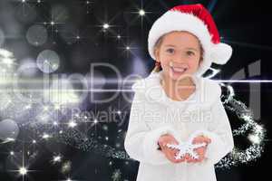 Composite image of festive little girl holding snowflake