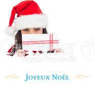 Composite image of festive brunette holding a gift