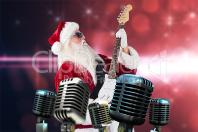 Composite image of santa playing electric guitar