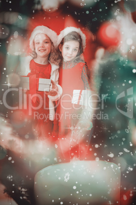 Composite image of festive little girls smiling at camera with g