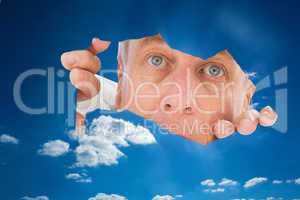 Composite image of older man looking through rip