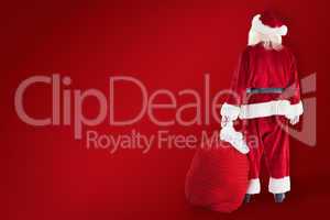 Composite image of santa carrying sack of gifts