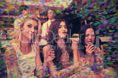 Composite image of happy friends drinking shots together